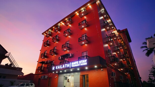 A multi-story building with balconies, a sign reading "KAILATH Safe Stay Tourist Home," and a white car parked in front. - Kailath Safe Stay Tourist Home (Tiruvalla)