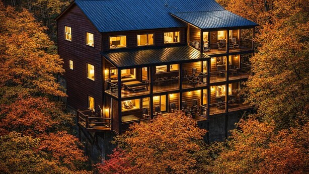 A multi-story wooden cabin with balconies, surrounded by autumn foliage. - Top Notch Lodge- Private Indoor Pool, Theater, Stunning Mountain Views (Pigeon Forge)