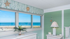 Une chambre avec vue sur l’océan, une commode, une table de chevet et un lit.
