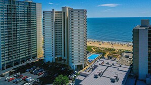 Un hôtel de grande hauteur doté d’une piscine sur le toit et offrant une vue sur la plage.