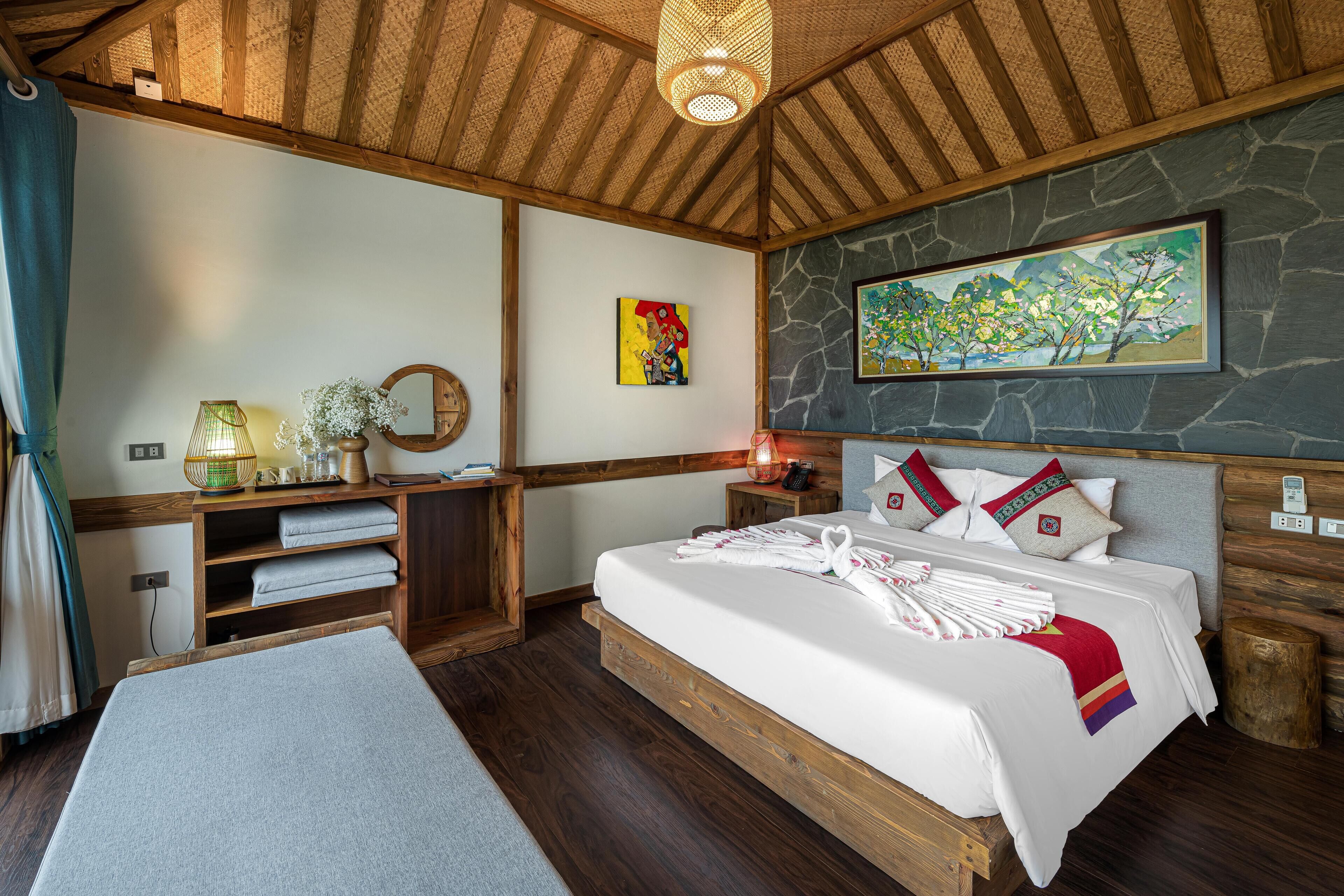 Un dormitorio elegante con una cama grande, cabecera de madera, pared de piedra y un cuadro.