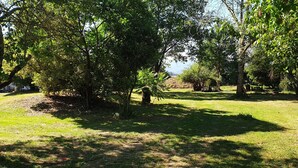 A grassy area with trees and a stone structure. - Peace and green charm (Salies-du-Salat)