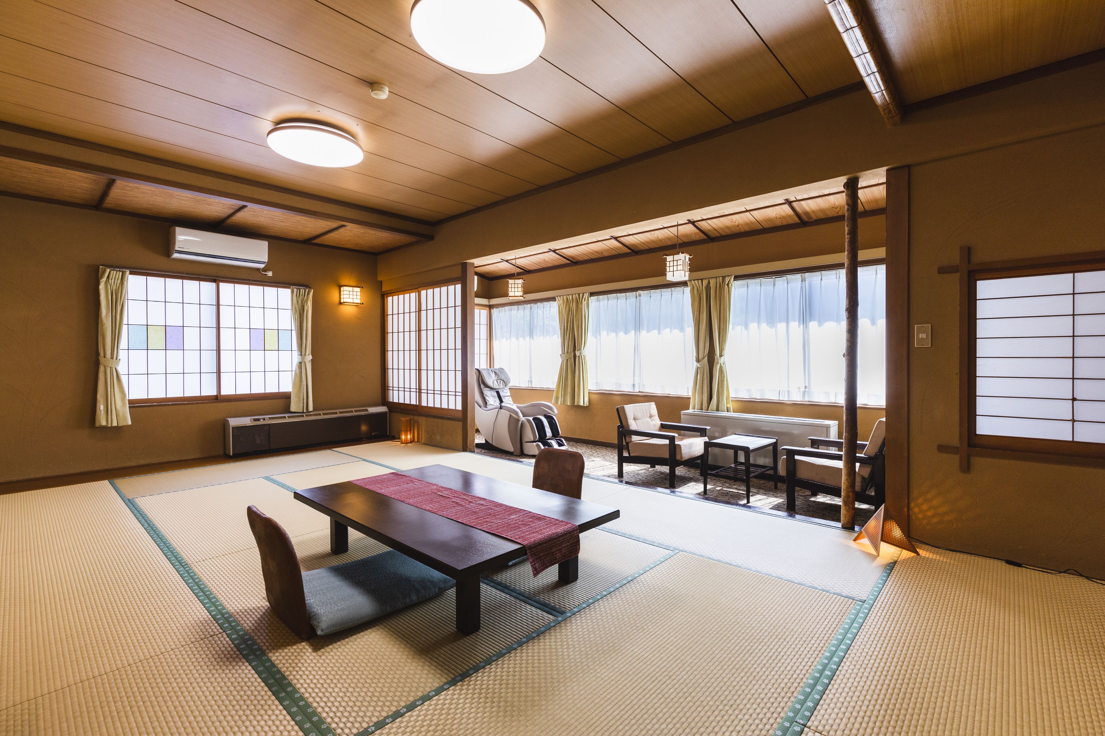 A traditional Japanese room with tatami flooring, a low table with cushions, and sliding doors.