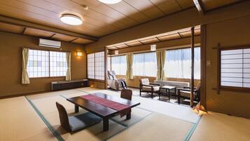 A traditional Japanese room with tatami flooring, a low table with cushions, and sliding doors.