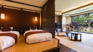A modern hotel room with two beds, a TV, a seating area with a table, and a view of the outdoors.