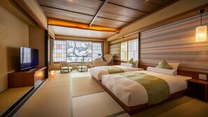 Une chambre d’hôtel avec un plafond en bois, un grand lit, une télévision et une vue sur les arbres par la fenêtre.