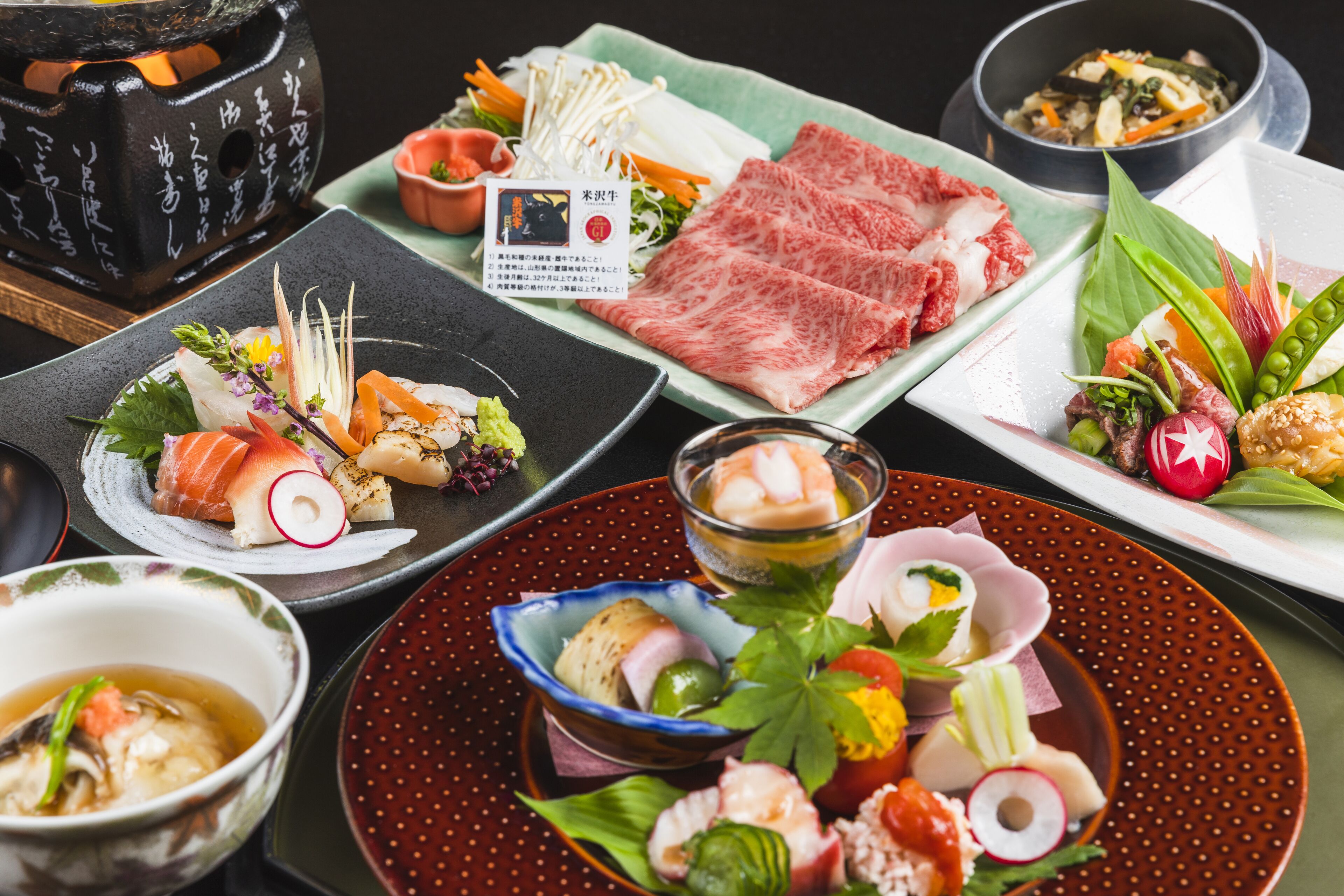 A variety of Japanese dishes including sushi, sashimi, and vegetables on different plates.