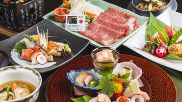 A variety of Japanese dishes including sushi, sashimi, and vegetables on different plates.