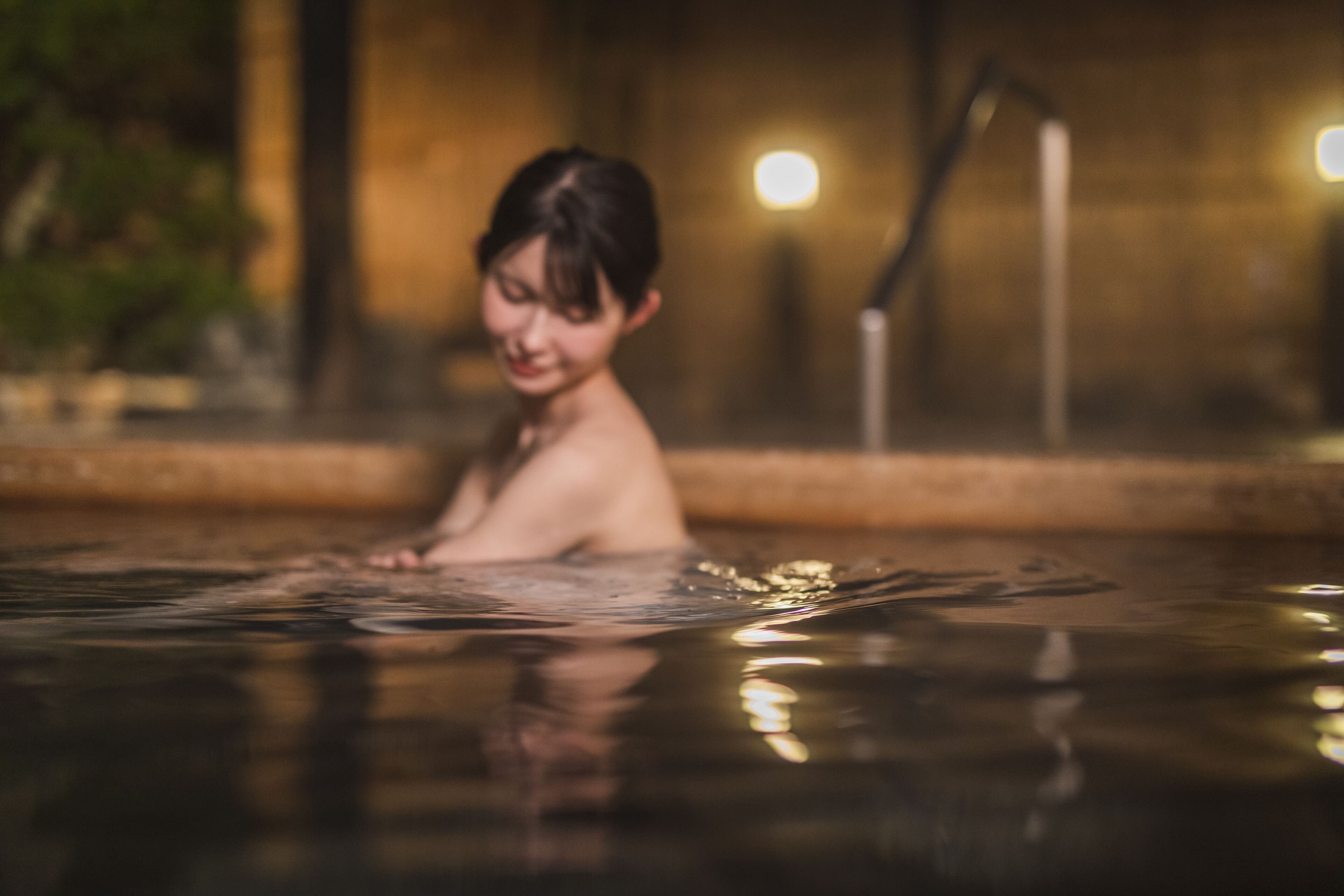 Une personne dans une baignoire, avec un arrière-plan flou.