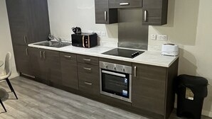 Een moderne keuken met donkere kastjes, een inbouwoven en een magnetron.