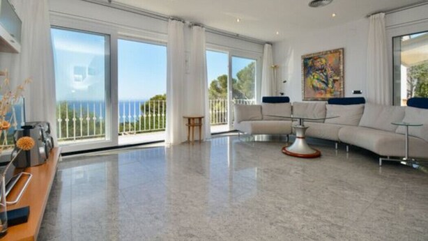 A spacious living room with a large window, a sofa set, and a coffee table. - Beautiful villa  in Platja d´Aro with sea views and a pool (Platja d'Aro)