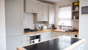 A modern kitchen with white cabinetry, a black countertop, and a built-in oven. - York Minster-3 Bed-sleeps 6-fireplace-free Parking (York)