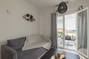 Suite exclusiva | Área de sala de estar | Televisión de 55 pulgadas con canales vía satélite 