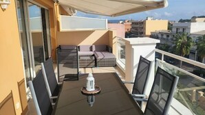 Ein Balkon mit Tisch, Stühlen und einer Sitzecke.