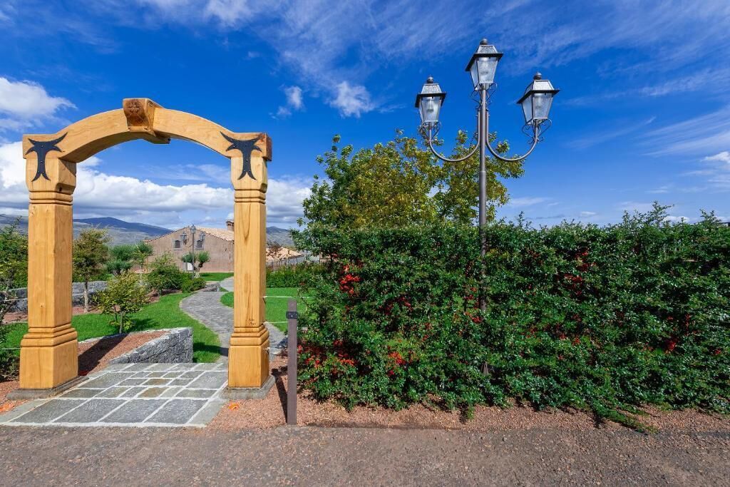 Un arco de madera con un farol cercano.
