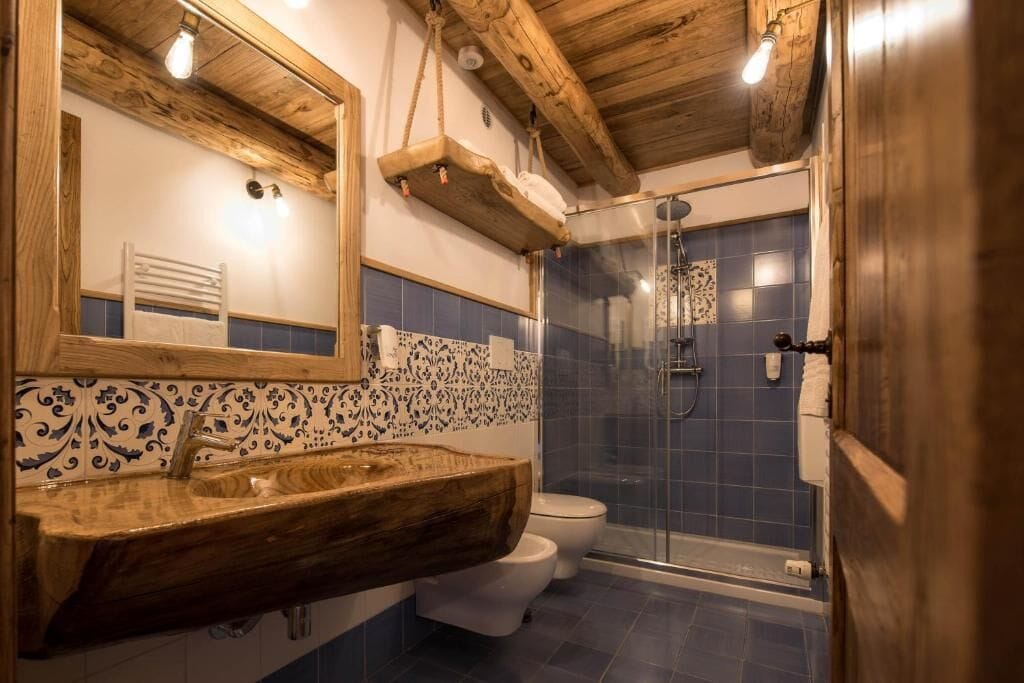 Un baño con tocador de madera, inodoro blanco y mampara de cristal.