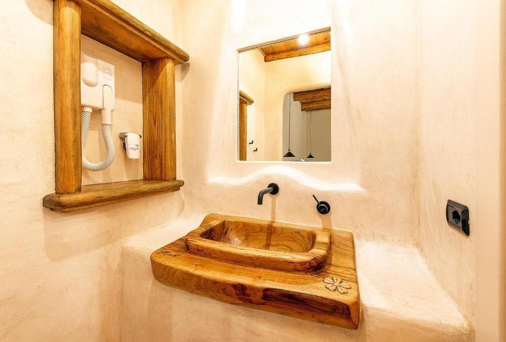 A bathroom with a wooden sink, a mirror, and a towel rack.