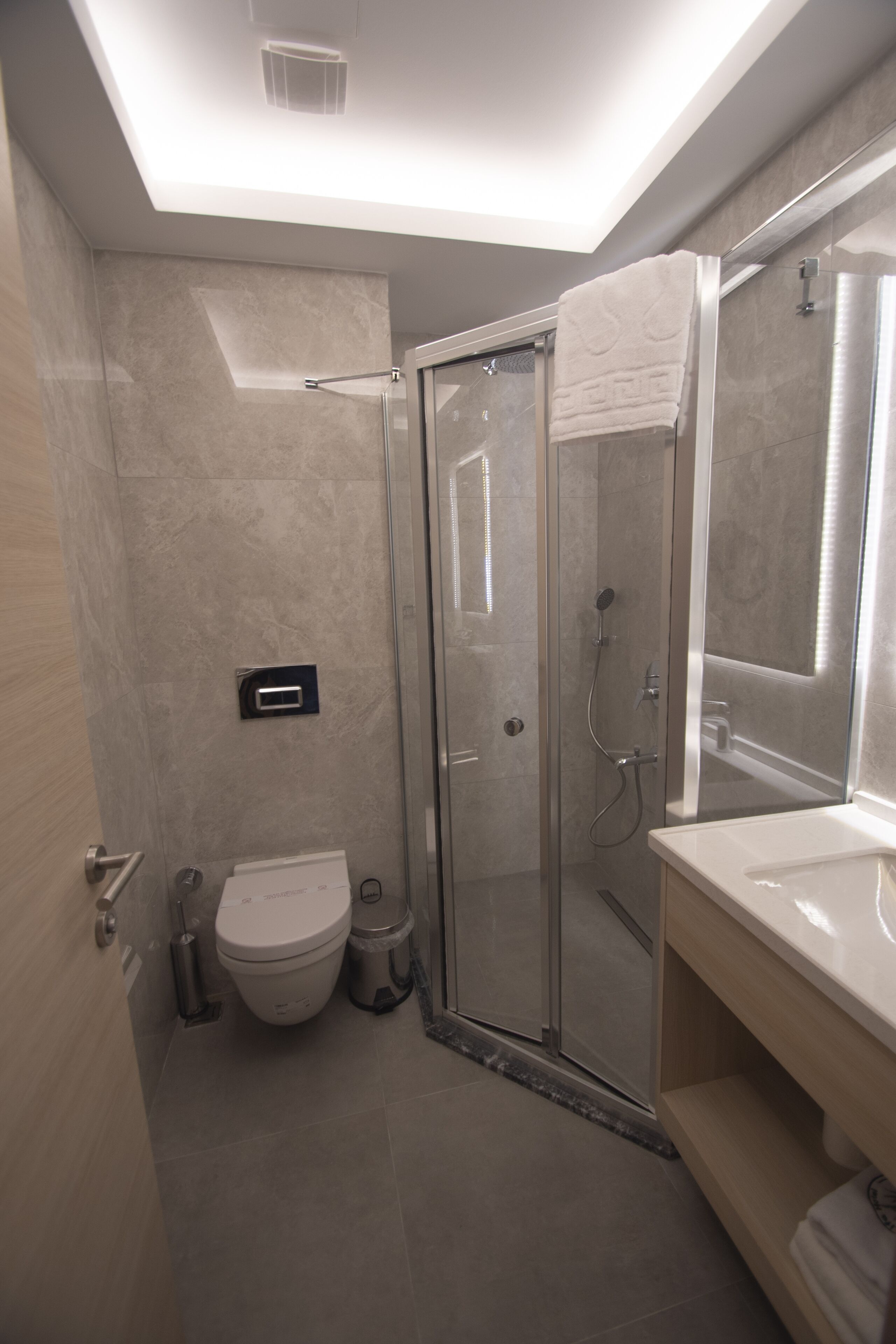 Une salle de bain moderne avec une douche à parois de verre, des toilettes et un lavabo avec un miroir.