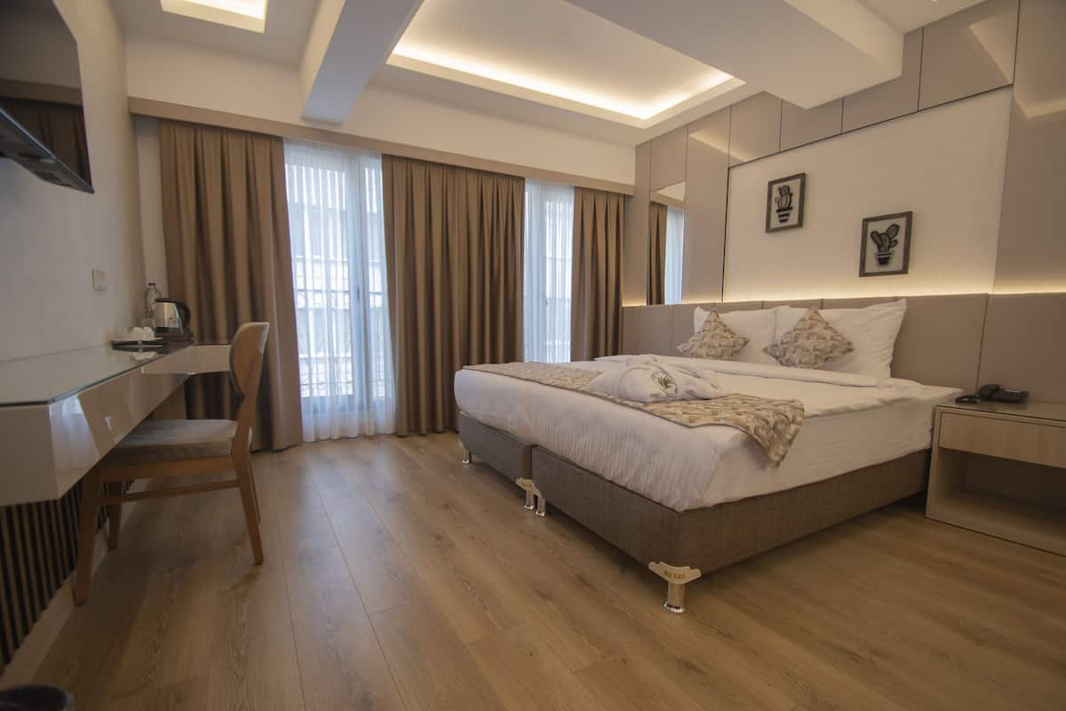 Ein modernes Hotelzimmer mit einem großen Bett, einem Schreibtisch und einem Stuhl.