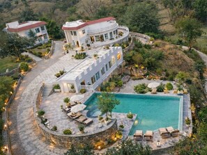 A luxurious villa with a swimming pool, outdoor seating, and a landscaped garden. - The Sky Imperial Pavoreal Jungle Resort (Kumbhalgarh)