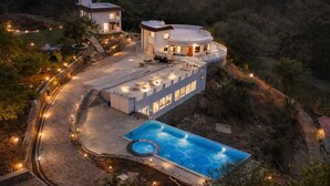 A luxurious villa with a swimming pool, multiple guest rooms, and a circular building with a covered patio. - The Sky Imperial Pavoreal Jungle Resort (Kumbhalgarh)