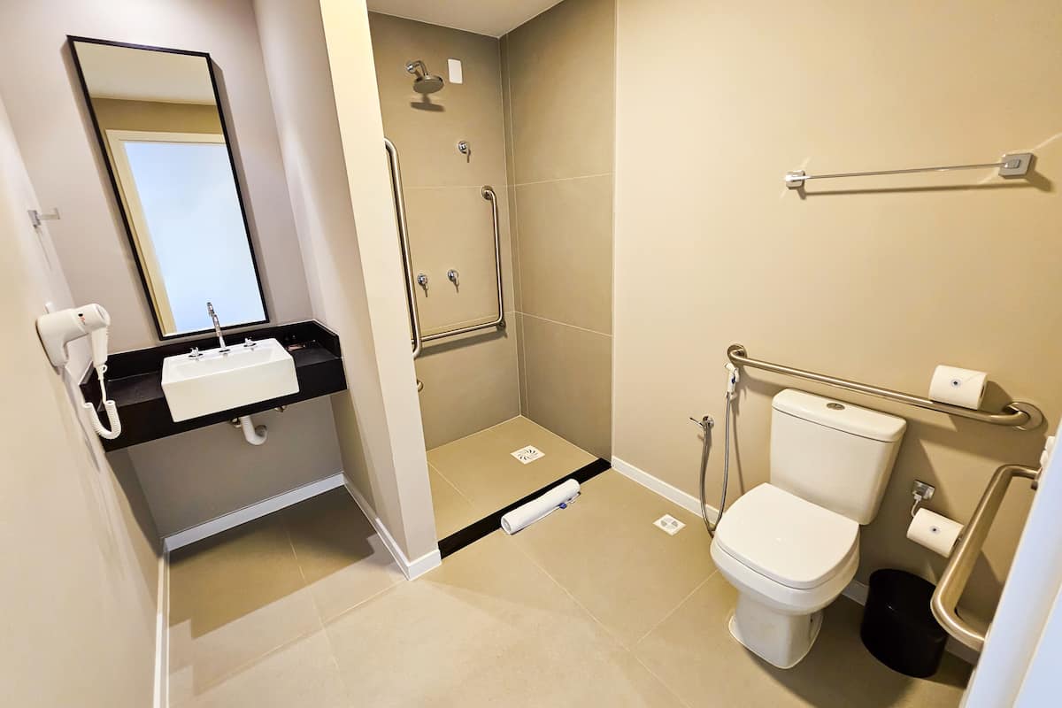 A modern bathroom with a shower, toilet, and sink.