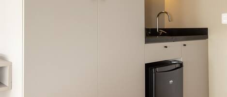 A compact kitchen with a microwave, sink, and refrigerator.