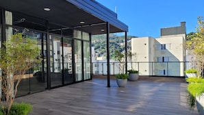 A modern building with large glass windows and a wooden deck. - Bewiki (Florianópolis)