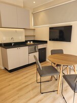 Una cocina moderna con comedor, que incluye horno empotrado, microondas y refrigerador.