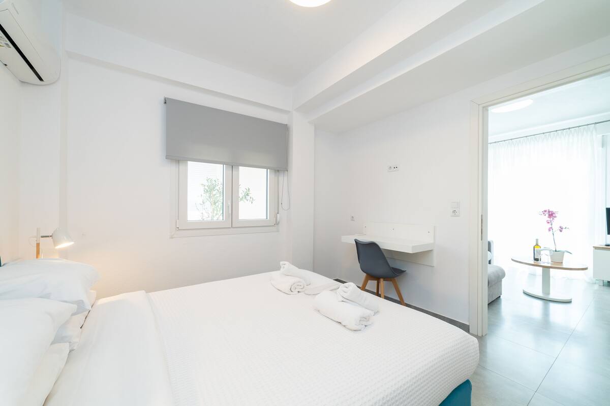 Ein modernes Hotelzimmer mit einem großen Bett, einem Schreibtisch und einem Sessel.