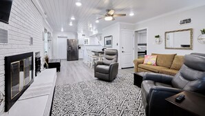 A modern living room with a fireplace, leather sofas, and a patterned rug. - Family & Friends Paradise on the lake (Rockwell)