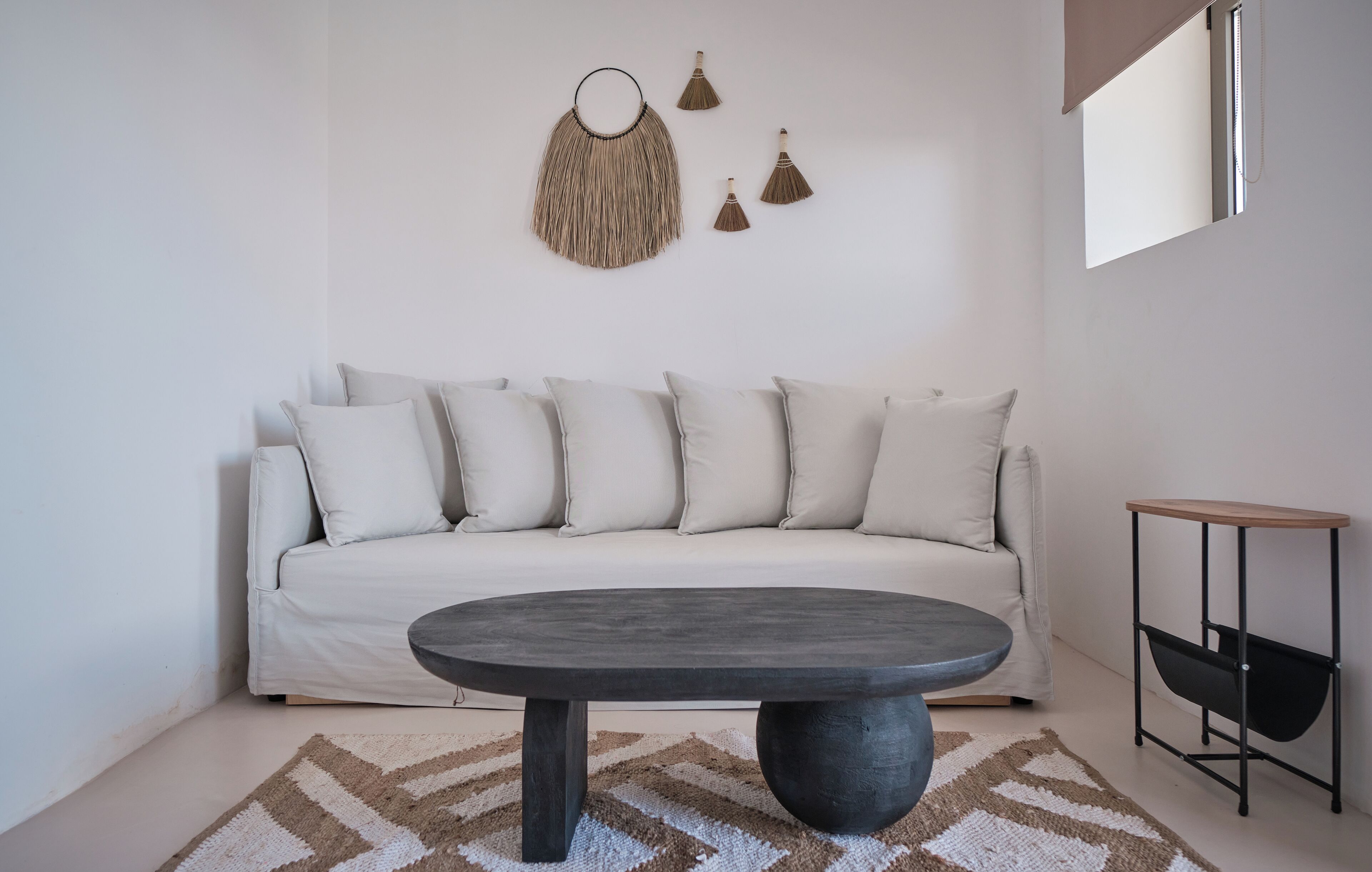 A modern living room with a white sofa, a round coffee table, and a minimalist decor.