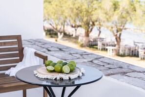 A round table with a wooden board and a white cloth, holding several limes. - Eden Kythira (Kithira)