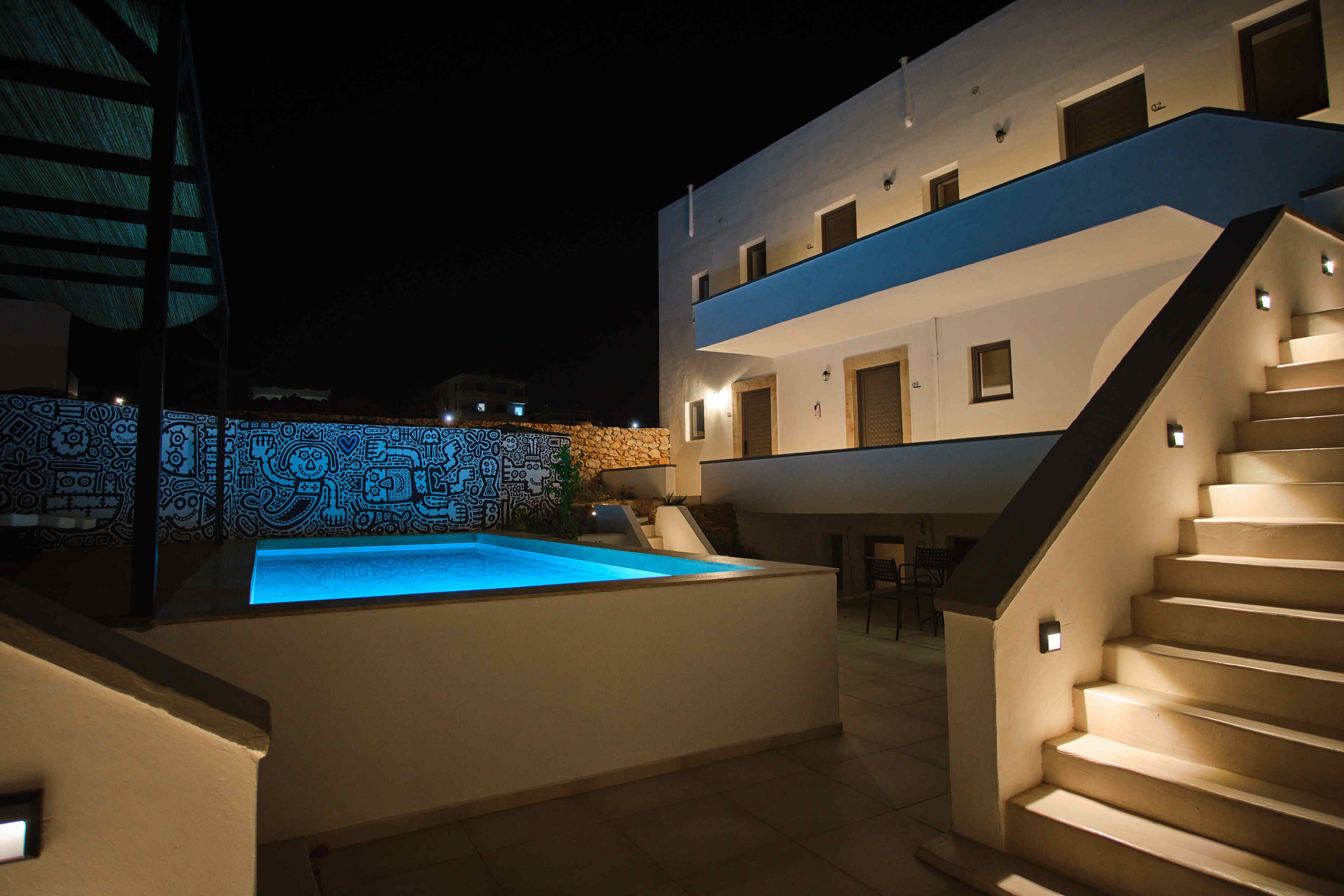 A modern building with a pool, outdoor seating, and a staircase.