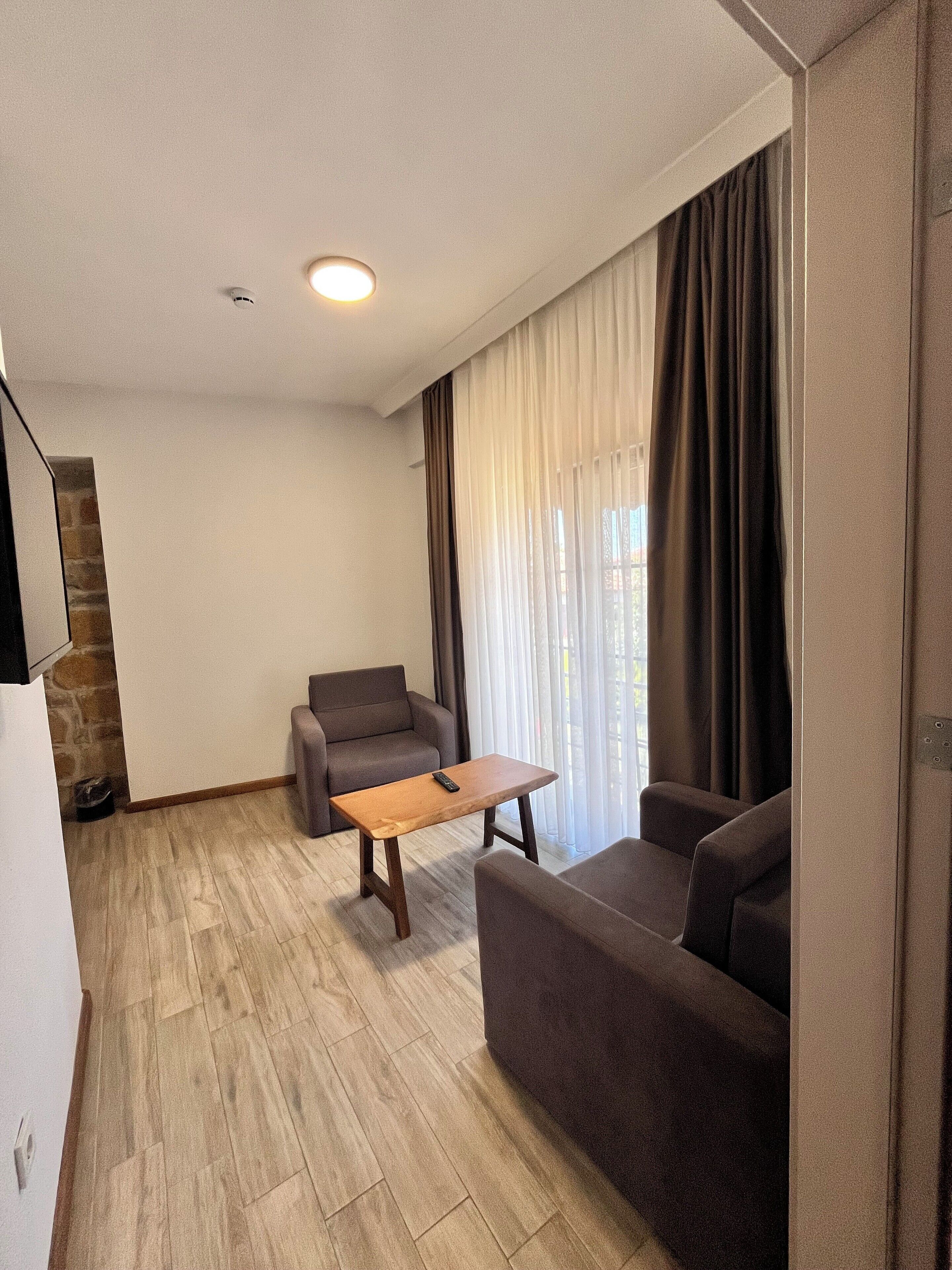 Un salon moderne avec une table basse en bois, deux canapés et un mur d’accent en pierre.