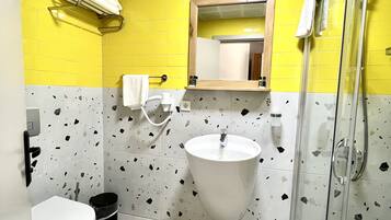 A bathroom with a white sink, a toilet, and a shower.