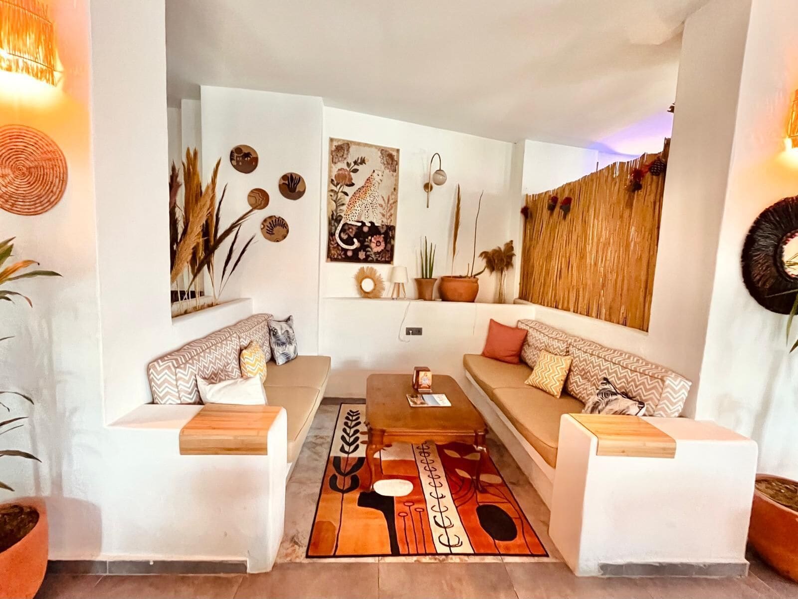 Una sala moderna con dos sofás blancos, una mesa de centro y decoración en las paredes.