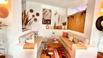 Una sala moderna con dos sofás blancos, una mesa de centro y decoración en las paredes.