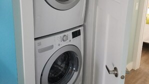 Un lavadero pequeño y con dos puertas, con exterior blanco y pared interior azul claro.