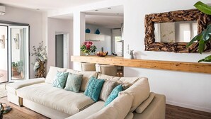 Un salon moderne avec un canapé, une étagère en bois et un grand miroir.