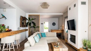 Un salon moderne avec un canapé, une table basse et un téléviseur fixé au mur.
