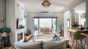 Un salon moderne comprenant un canapé, un coin repas et une vue sur l’extérieur.
