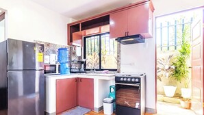 Cocina pequeña equipada con refrigerador, estufa y lavaplatos.
