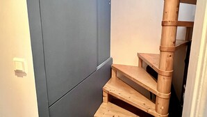 Un escalier étroit avec des marches en bois menant à un palier.
