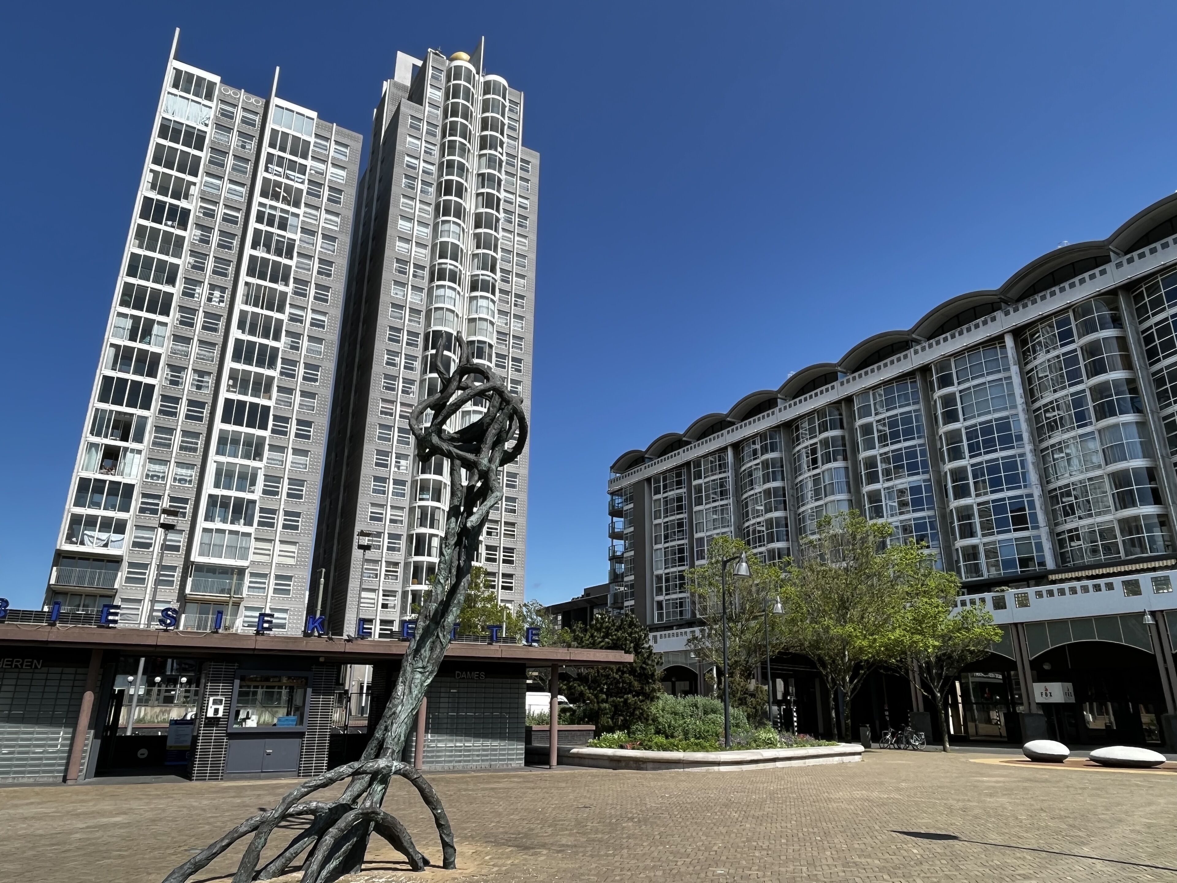 A modern building with a unique sculpture in the foreground.