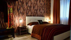 Une chambre à coucher avec un lit, une table de chevet, une lampe et un rideau.