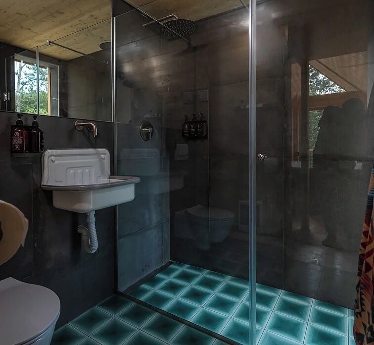 Een badkamer met een douchecabine van glas, een wit wastafelmeubel en een toilet.