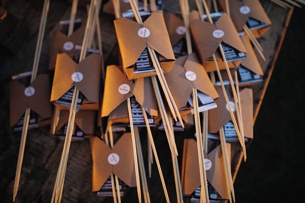 A collection of brown paper bags with handles, each containing a small item.