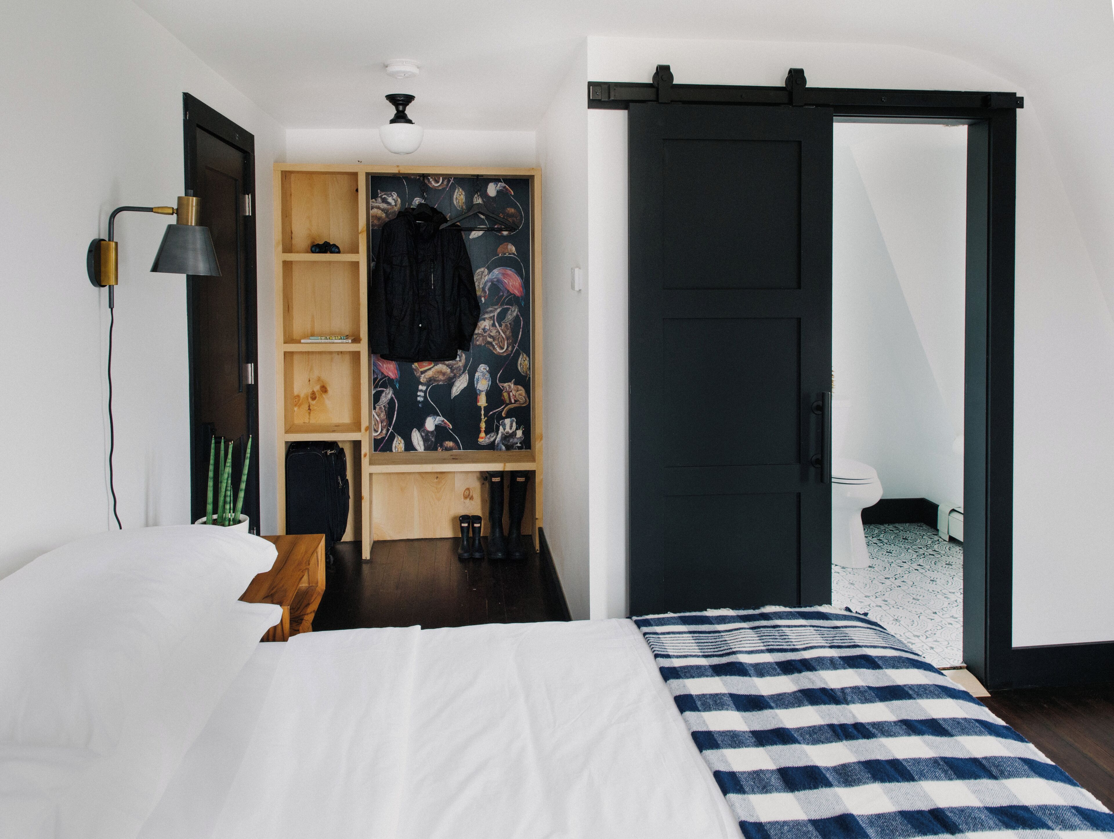 Een slaapkamer met een bed, een kledingkast, een bureau en een badkamer.