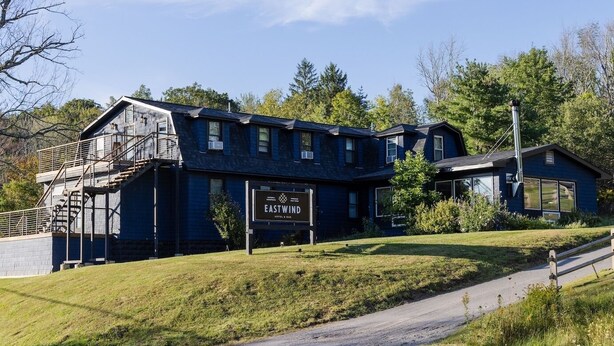 A two-story building with a sign reading "EASTWIND HOTEL & BAR".